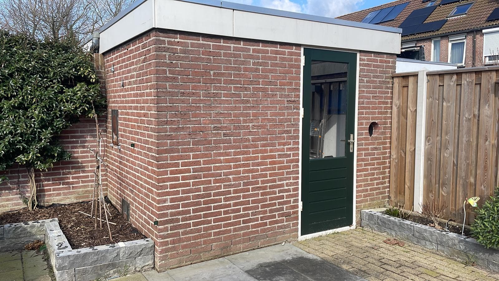 Geschilderde groene deur van een stenen schuur